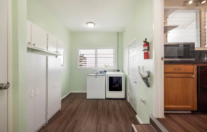 Laundry area. Steps on the right lead to the kitchen. Door just to the right of dryer lead outside to the side lanai.